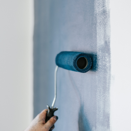 Paint & SuppliesA blue paint roller painting a wall.